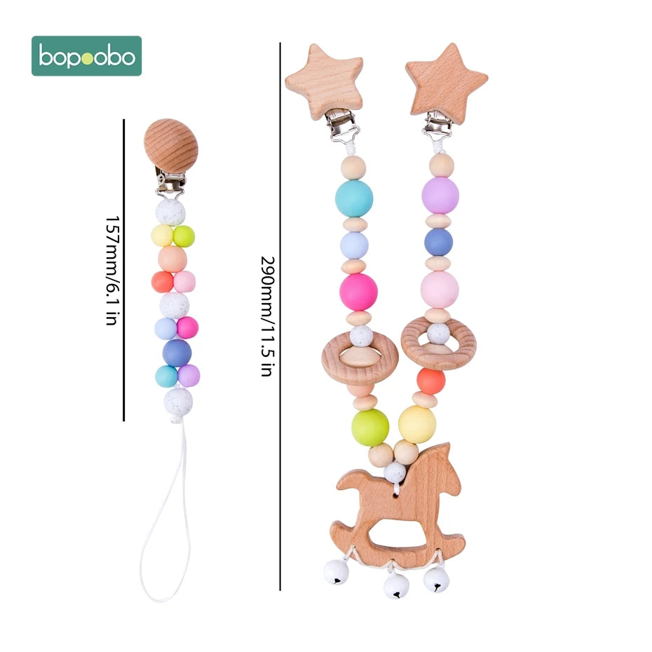 Two colorful beaded pacifier clips with wooden clasps; one is 157mm with round beads, the other is 290mm with a wooden horse and star shapes. Brand logo "bopoobo" at the top left.