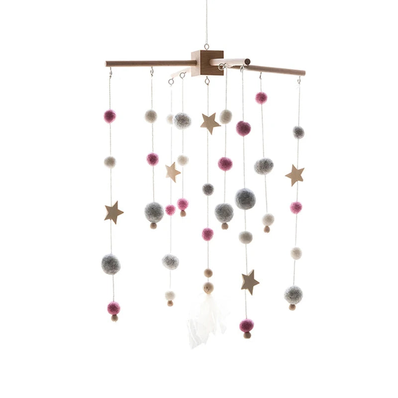 Wooden baby mobile with colorful pom-poms and stars suspended from strings, creating a playful and cozy decor.
