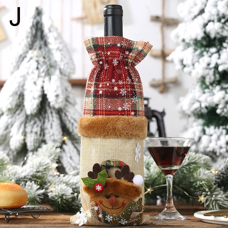 Festive scene with a wine bottle in a red plaid cover featuring a reindeer design. Snowy trees in the background and a filled cocktail glass sit alongside the bottle on a wooden surface.