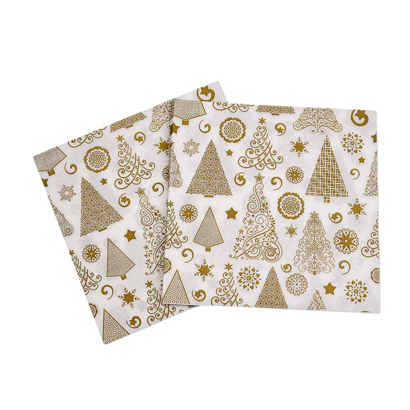 Two white napkins with intricate gold holiday designs featuring Christmas trees, stars, and decorative patterns. The overlapping napkins enhance the festive look.