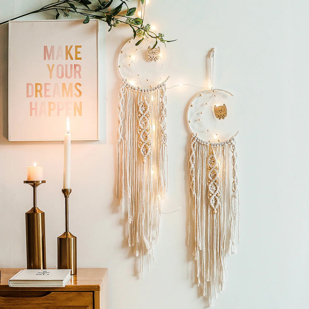 Wall decor with two boho dreamcatchers and a motivational quote poster. Fairy lights and candles add warmth. A wooden table holds books beside the candles.