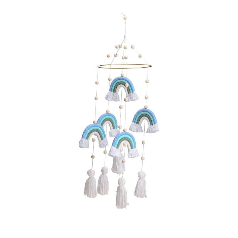 Hanging mobile with blue and green rainbows and white tassels, suspended from a circular frame. Decorated with wooden beads, it adds a playful touch to any space.