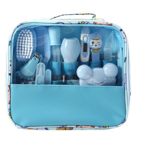Baby grooming kit in a blue case with a transparent front, featuring a nail clipper, comb, brush, thermometer, and more, all secured with elastic bands for organized storage.