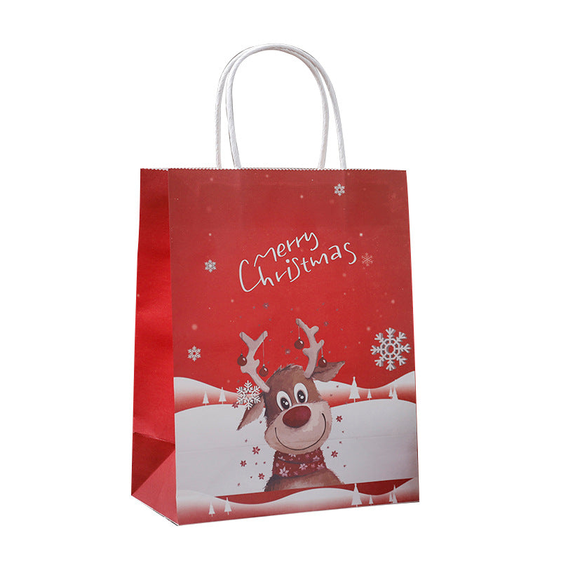 Red gift bag with a smiling cartoon reindeer wearing a scarf, snowflakes, and white "Merry Christmas" text. White handles on top complete the festive design.