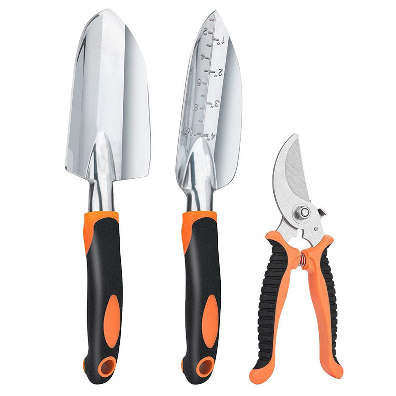 Three gardening tools with orange and black handles: a trowel, a transplanter marked with measurements, and pruning shears. All have metal heads and ergonomic grips.