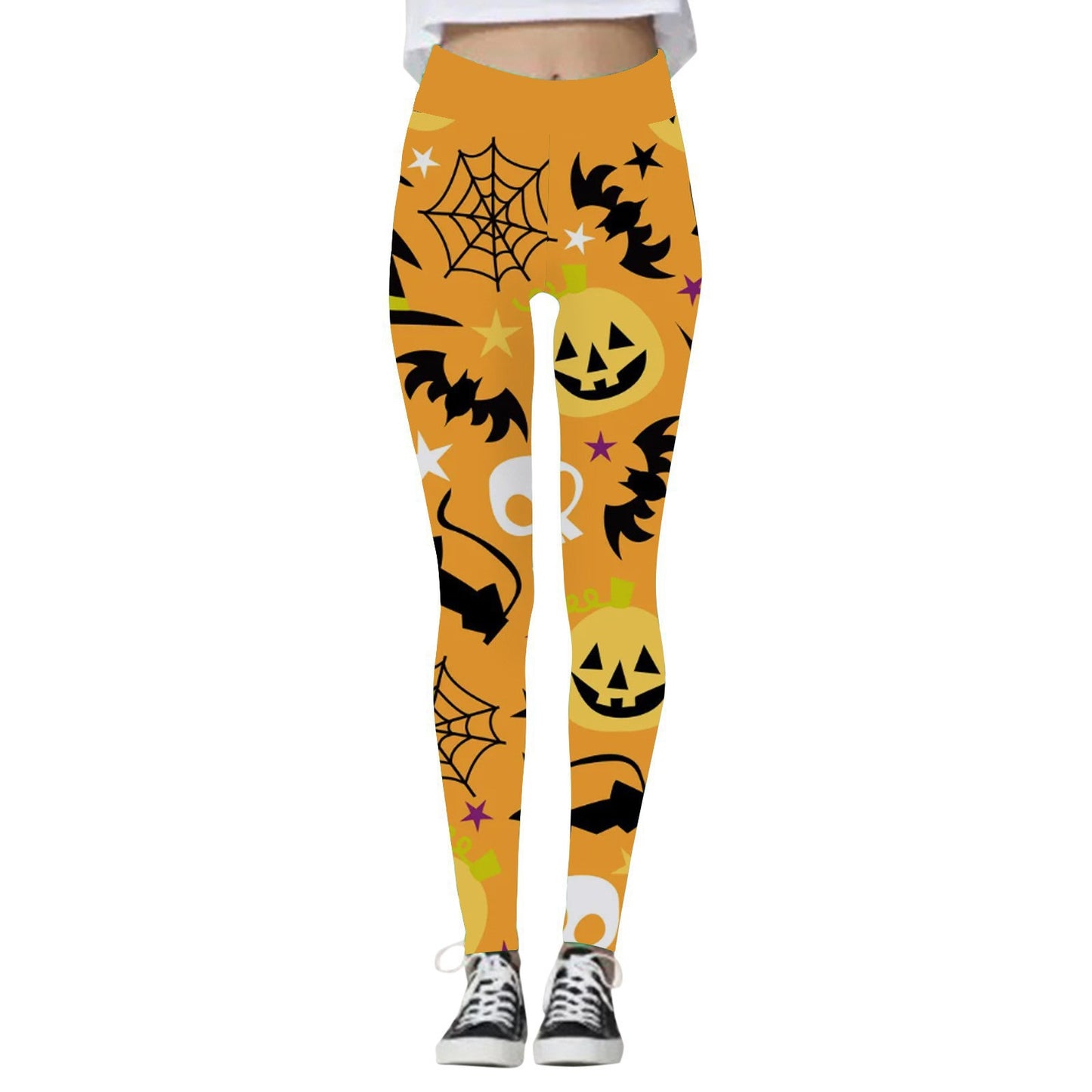 Orange leggings with Halloween patterns featuring black bats, jack-o'-lanterns, spider webs, skulls, stars, and a green bubbling cauldron, paired with black sneakers.