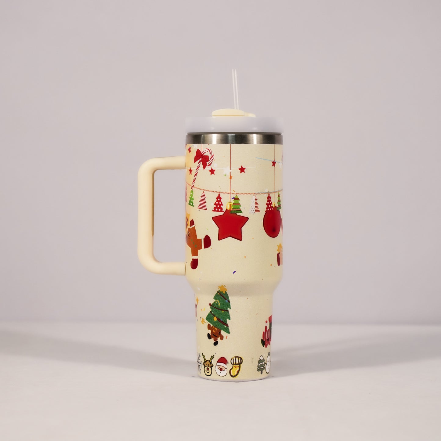 Tall beige mug with handle, featuring festive Christmas designs like trees, stars, and Santa. It has a clear lid with a straw, set against a plain background.