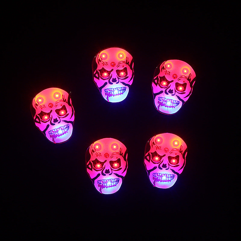 Five illuminated skull masks with glowing red eyes and mouths, set against a black background. The eerie design enhances their menacing expression.