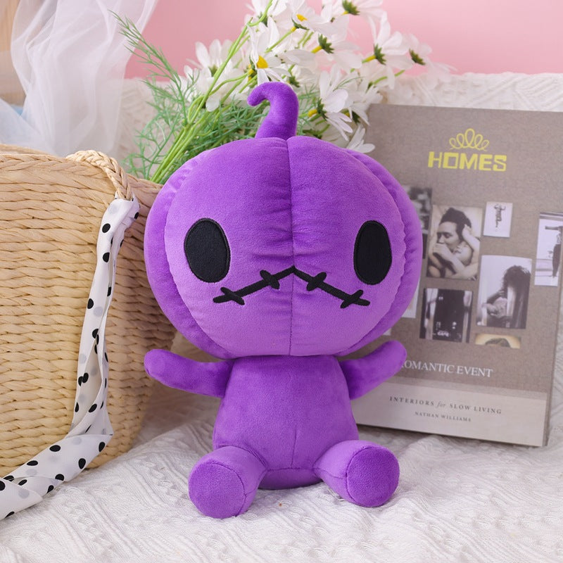 Purple plush toy with black oval eyes and stitched mouth sits near a woven basket. Background features white flowers and a magazine titled "HOMES" on a textured fabric.