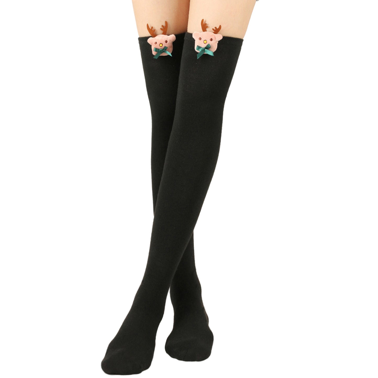 Black thigh-high socks with cute reindeer embellishments near the top, featuring pink faces, brown antlers, and green bows, worn by a person standing with legs crossed.