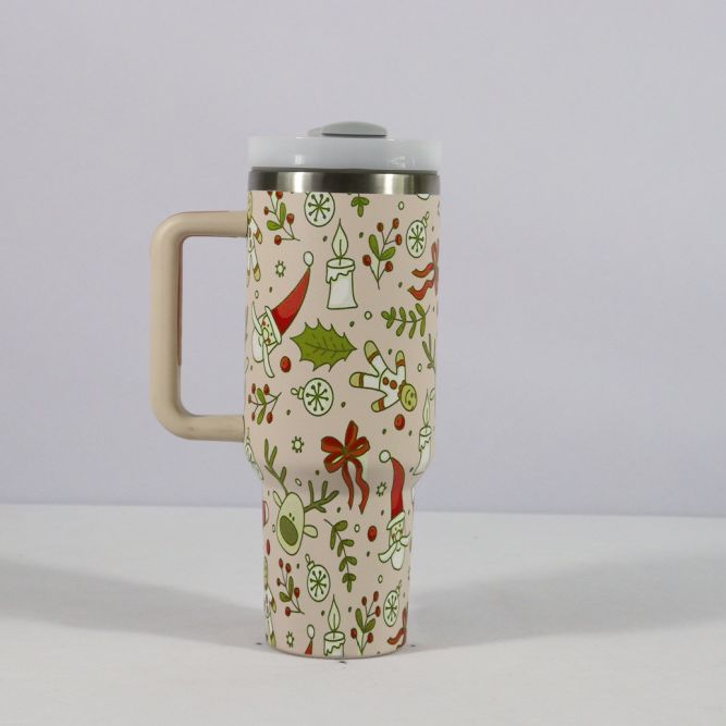 A festive travel mug with a beige handle, adorned with Christmas-themed illustrations of Santa hats, candles, holly, and snowflakes on a light background.