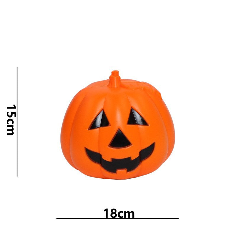 Orange jack-o'-lantern with a smiling face, featuring triangular eyes and a jagged mouth. The pumpkin measures 15 cm in height and 18 cm in width.