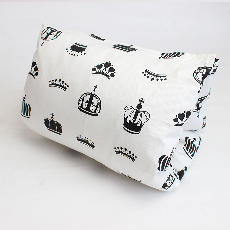 White pillow with black crown patterns of various styles scattered across the fabric, set against a plain background.