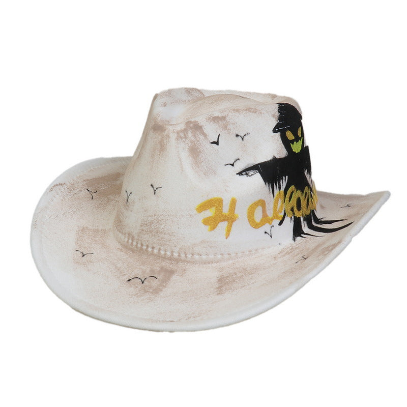 White cowboy hat with a brown tint, featuring black birds and the word "Halloween" in yellow. It has a spooky scarecrow design with a yellow-eyed face on the band.