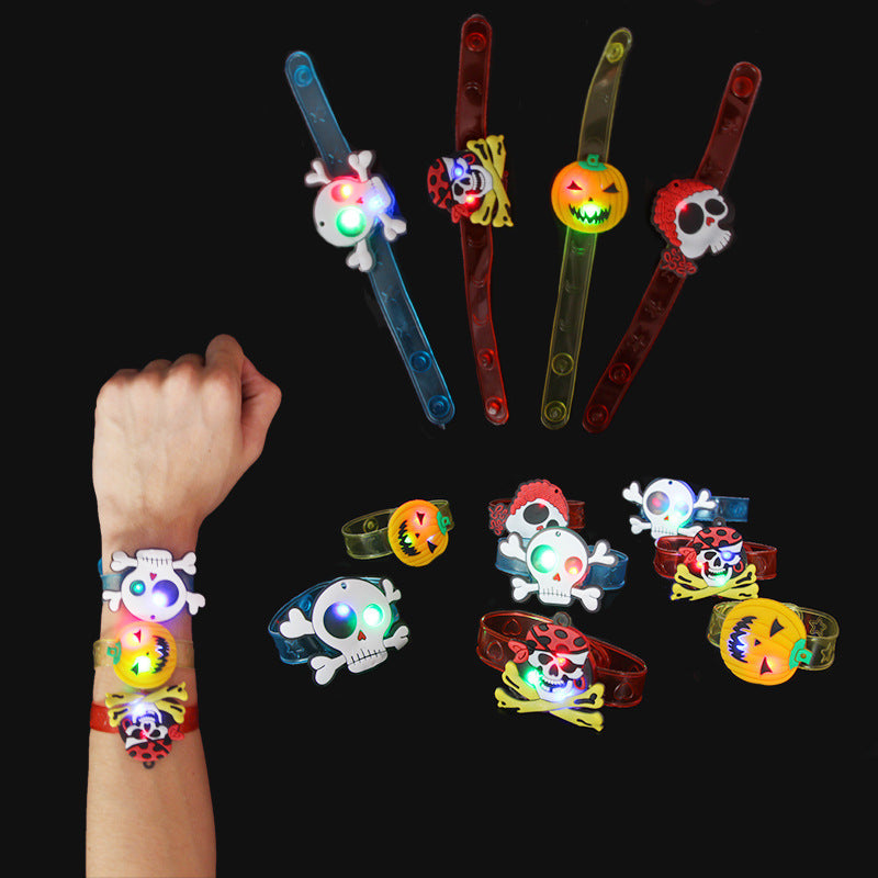 Halloween-themed light-up bracelets with skull, pumpkin, and pirate designs. Various colors, some worn on a wrist, against a black background.