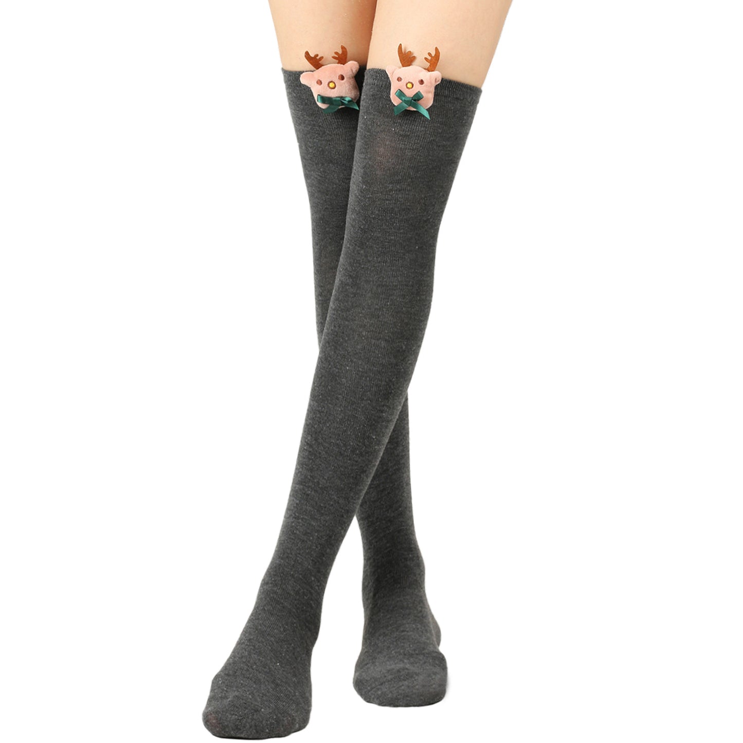 Gray knee-high socks with cute plush reindeer designs at the top, featuring antlers and green bows, worn by a person standing with legs crossed on a white background.