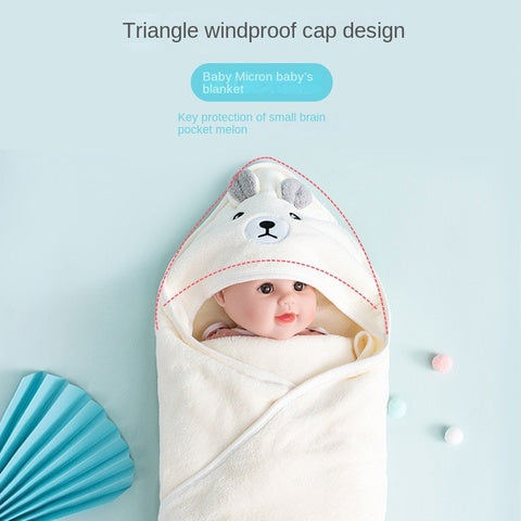 A baby wrapped in a cream-colored blanket with a bear-themed hood. Text reads, "Triangle windproof cap design." The blanket is on a light blue background with small decorative items.