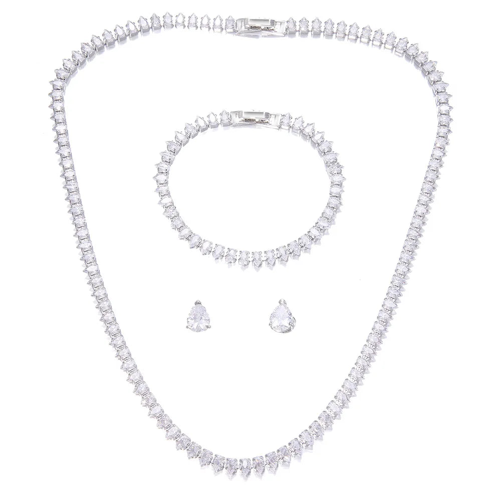 A diamond jewelry set featuring a necklace, bracelet, and pair of earrings, all adorned with sparkling, clear-cut stones on a white background.