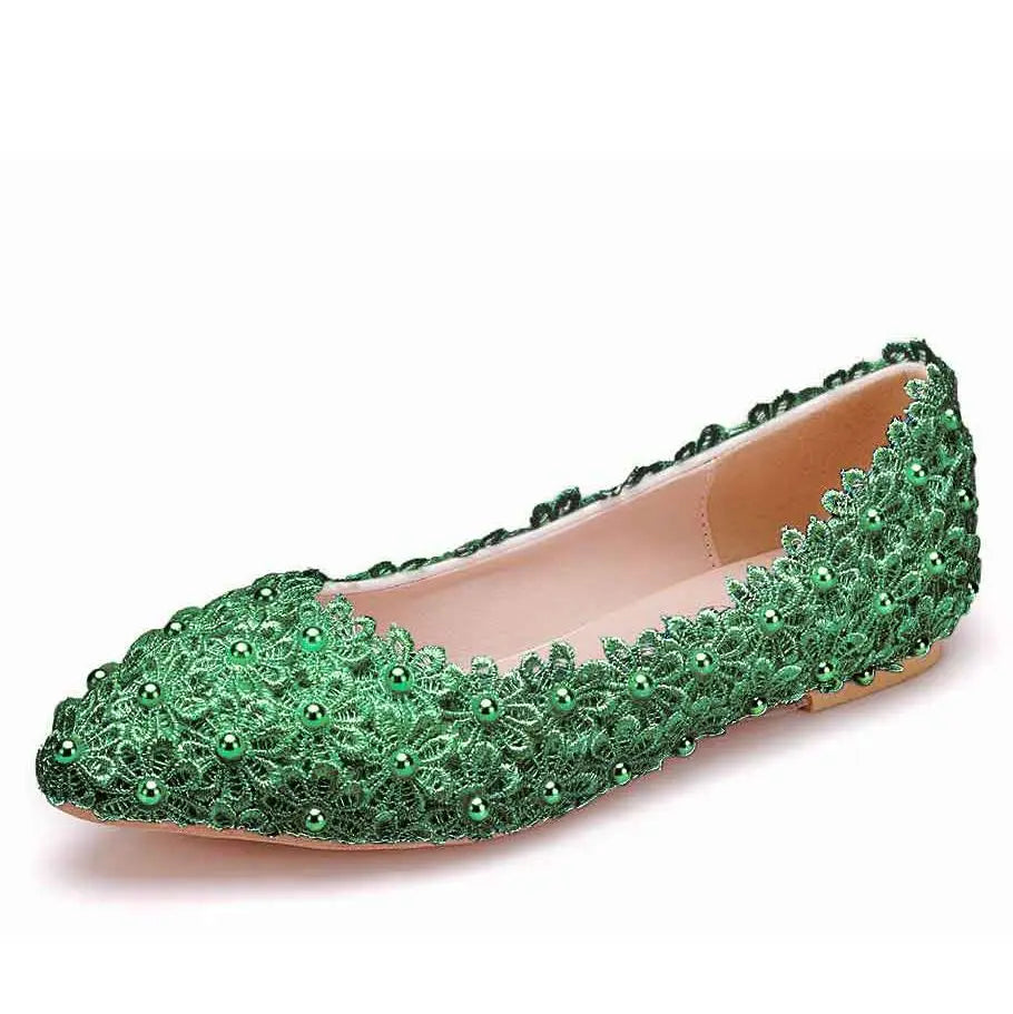 A green lace flat shoe adorned with intricate floral patterns and small green beads, featuring a pointed toe and a nude interior, displayed on a white background.