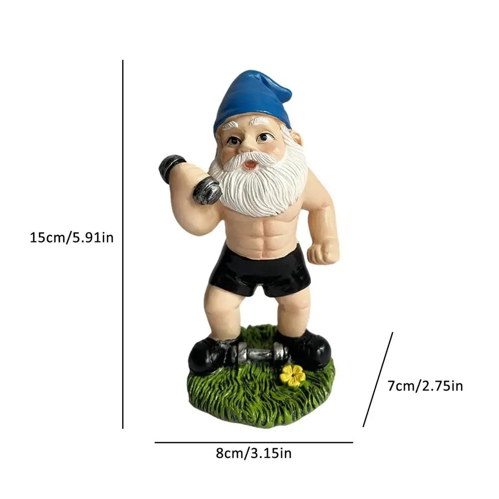 A muscular garden gnome with a blue hat lifts a dumbbell on a grass base. Measurements: 15cm tall, 8cm wide, 7cm deep.