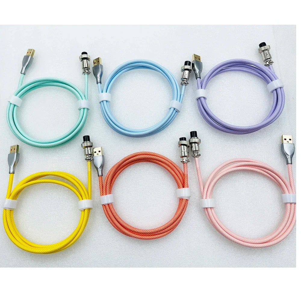 Six coiled USB cables in pastel colors—mint, blue, lavender, yellow, orange, and pink—are neatly arranged on a white background, secured with white straps.