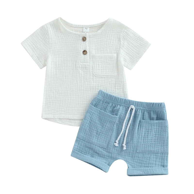 White short-sleeve baby shirt with two buttons and a pocket, paired with light blue elastic waist shorts featuring drawstring and two front pockets.