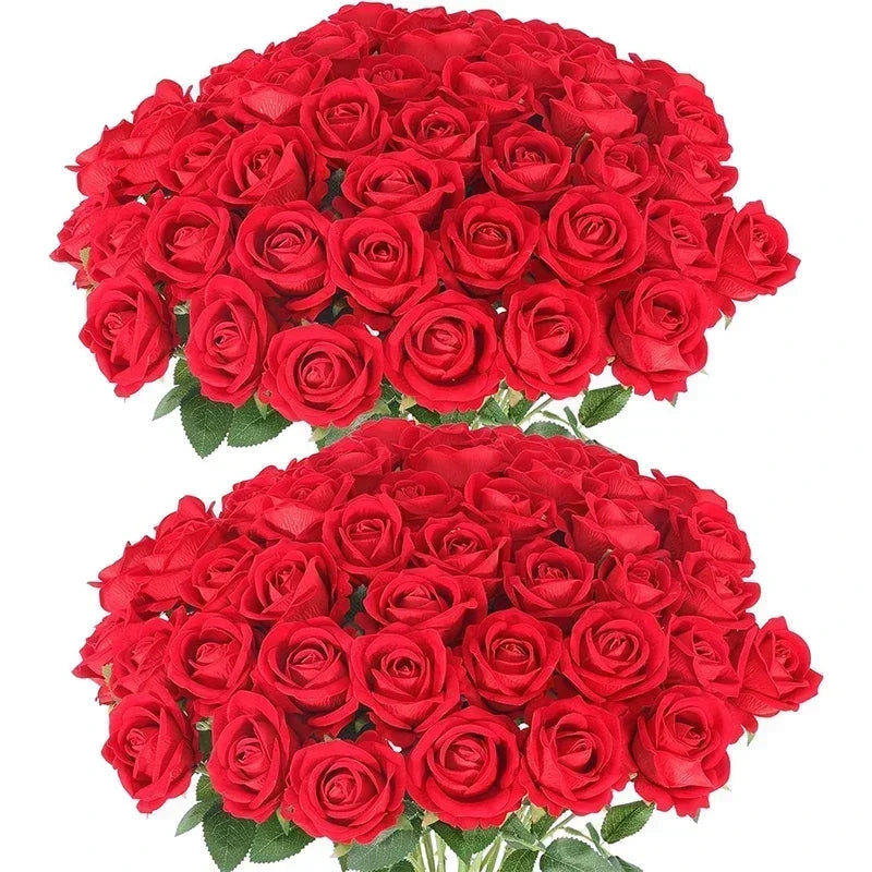 A large, lush bouquet of vibrant red roses with abundant petals and green leaves, arranged closely together, creating a striking visual of classic elegance and romance.