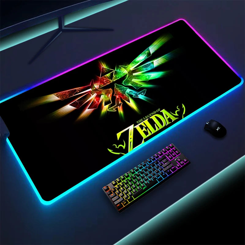 RGB-lit gaming setup featuring a large "The Legend of Zelda" themed mouse pad with glowing edges, a colorful RGB keyboard, and a black gaming mouse on a dark desk.