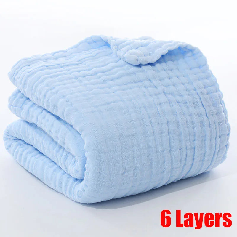 A folded light blue muslin blanket with a textured surface, labeled "6 Layers" in bold red text at the bottom right corner.