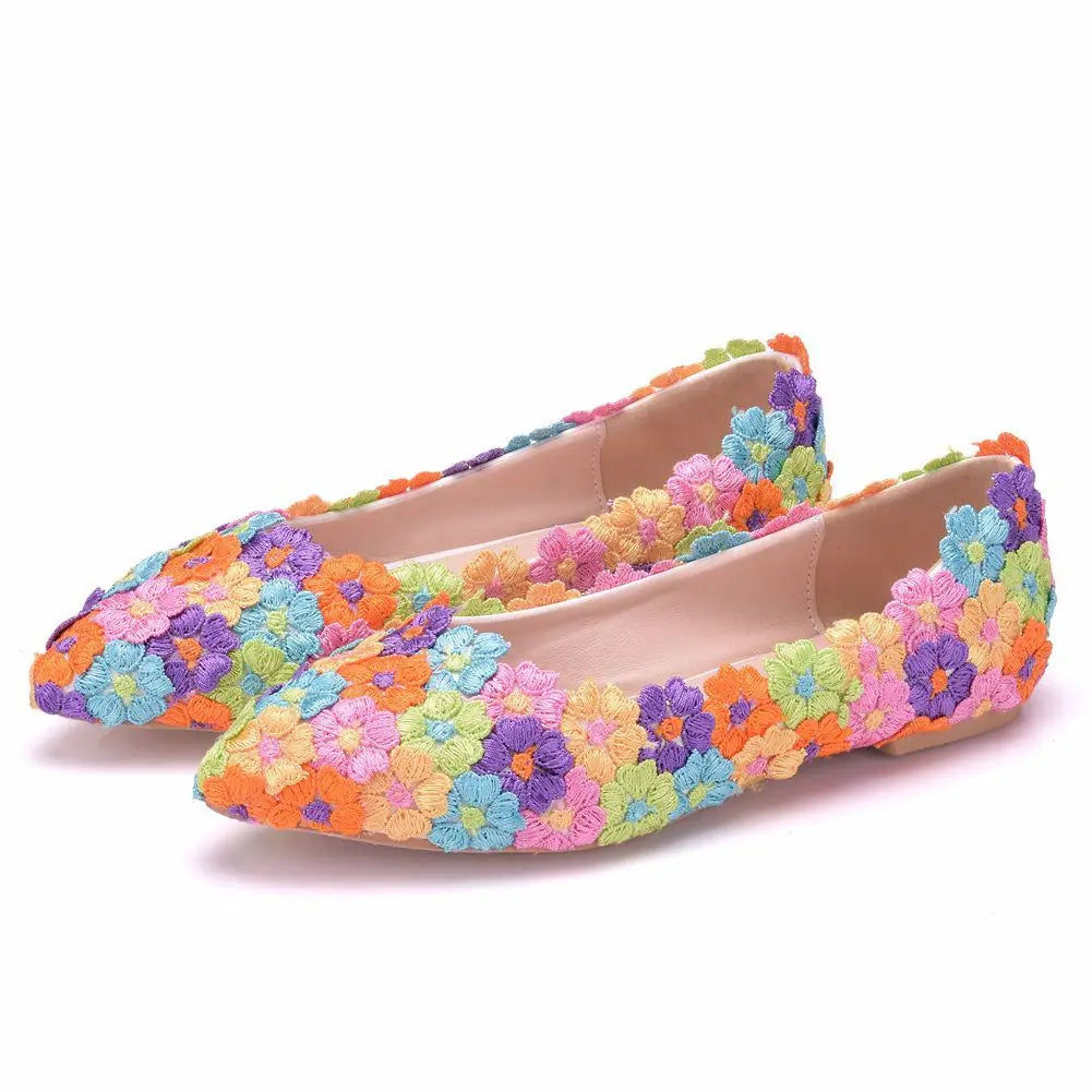 Colorful flats adorned with vibrant embroidered flowers in shades of orange, purple, blue, pink, and green. The pointed design adds a fashionable and playful touch.