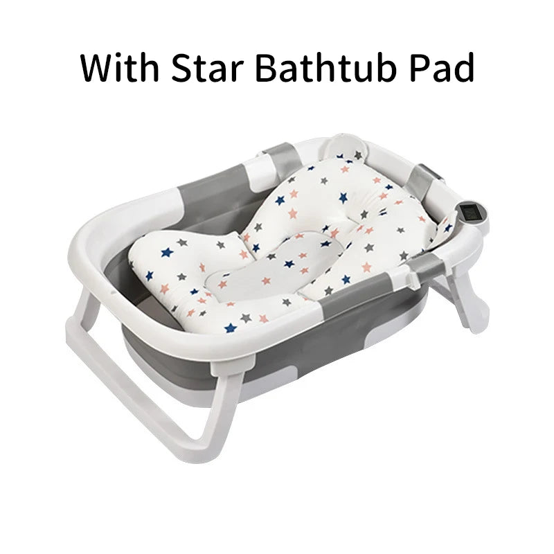 Gray and white baby bathtub with a star-patterned pad, featuring an ergonomic design and digital thermometer. Text above reads, "With Star Bathtub Pad."