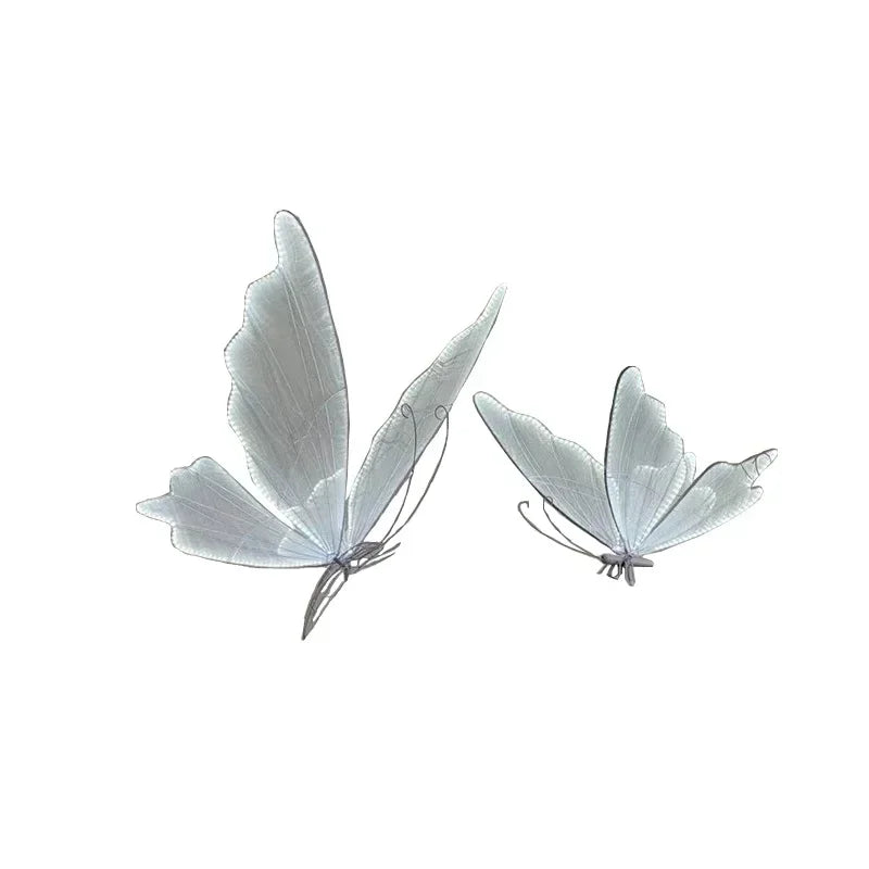 Two delicate white butterflies with intricate wing patterns appear to be in flight against a plain background, displaying a sense of lightness and grace.