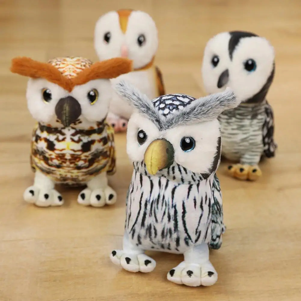 Four plush toy owls with varied colors and patterns, including white, brown, and gray markings, are arranged on a wooden surface, showcasing their wide eyes and soft textures.