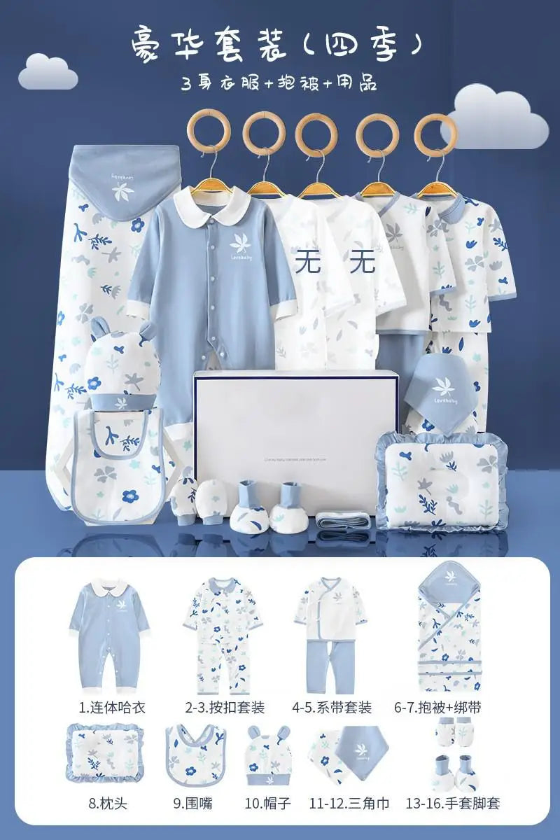 Baby clothing and accessory set in blue and white with floral prints, including onesies, bib, hat, blanket, mittens, and booties, displayed on hangers and neatly arranged on a table.