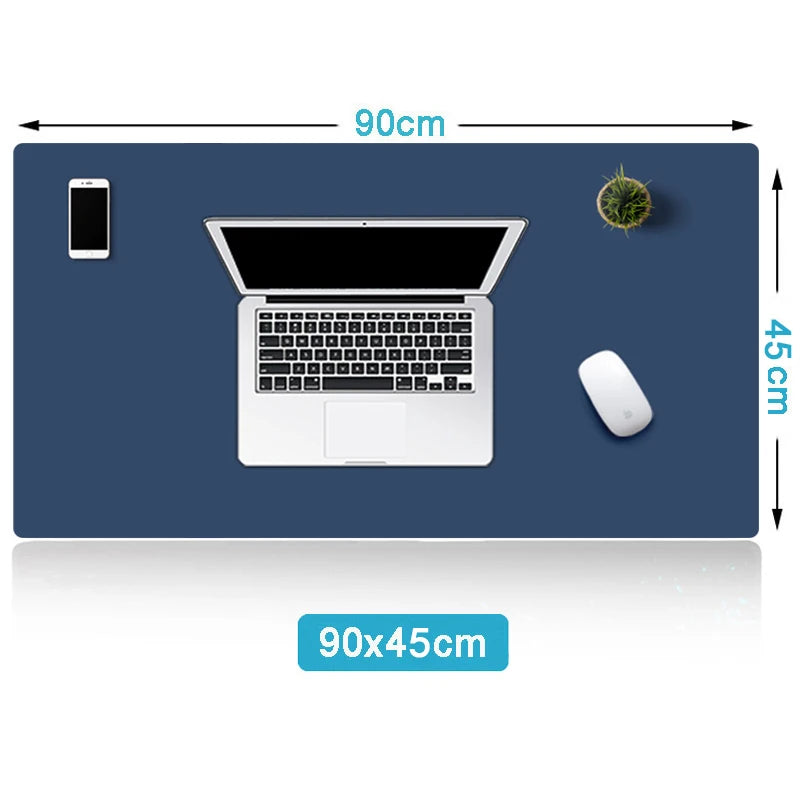 A 90x45cm navy blue desk mat with a laptop, smartphone, mouse, and small plant on top. The mat dimensions are marked on its edges.