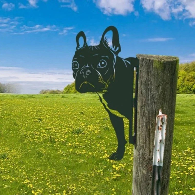 Silhouette of a French Bulldog on a post in a field of yellow flowers under a blue sky, creating an illusion that the dog is peering out from behind the post.