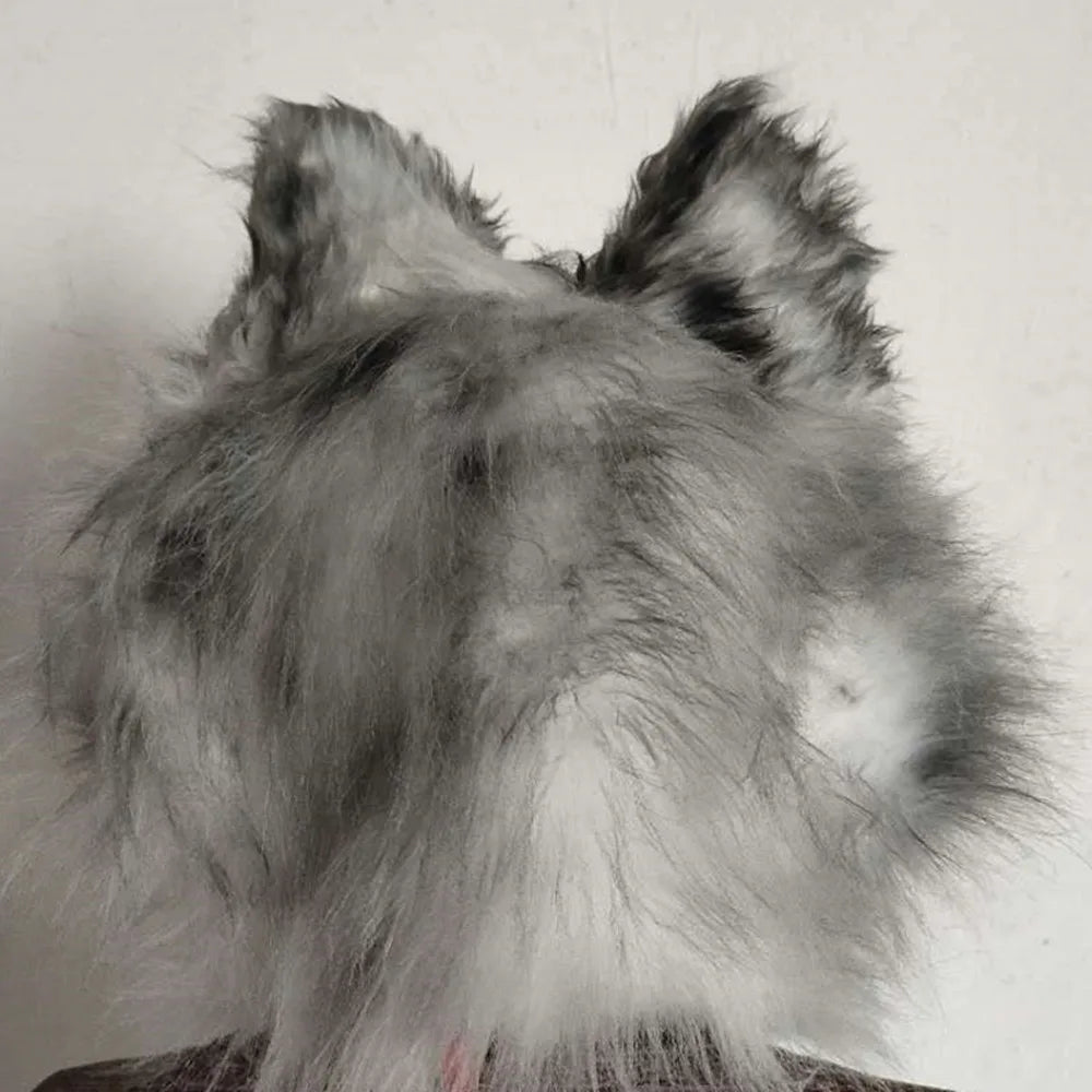 Fluffy grey and white object resembling a cat's head with pointy ears, viewed from the back against a plain background.