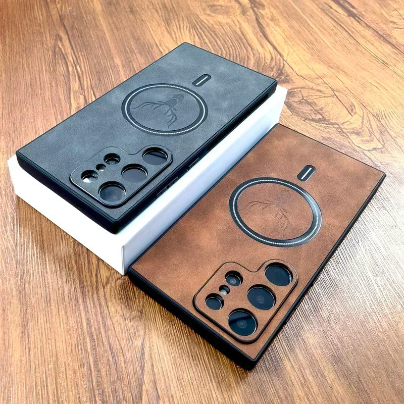 Two smartphones on a wooden surface display camera designs with circular cutouts. One is in a black leather case, the other in brown, both featuring an embossed logo.