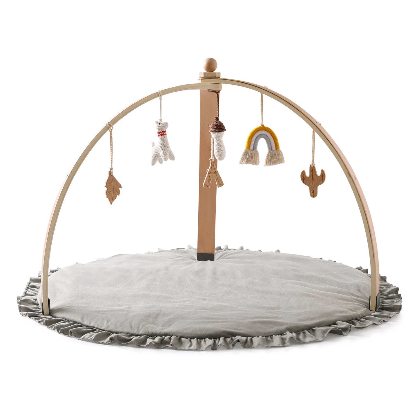Wooden baby play gym with hanging toys: a leaf, mitten, mushroom, rainbow, and cactus. Set on a round, gray padded mat with ruffled edges.