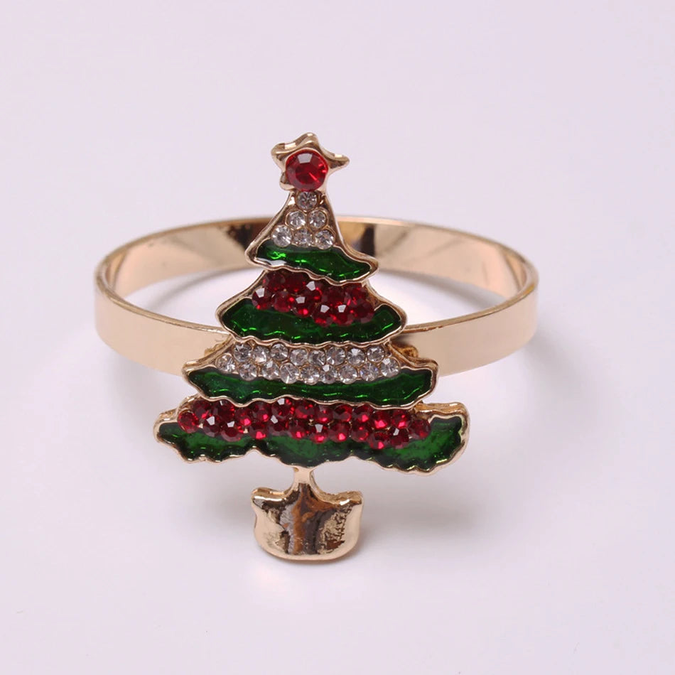 Gold ring featuring a Christmas tree design adorned with red, green, and clear gemstones, topped with a red star. The background is plain white.
