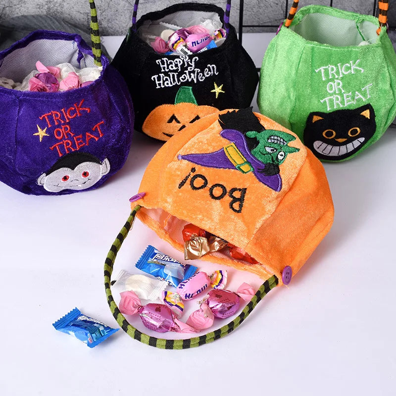 Four Halloween-themed treat bags filled with candies. The bags have designs of a vampire, pumpkin, black cat, and witch, with phrases like "Trick or Treat" and "Boo!"