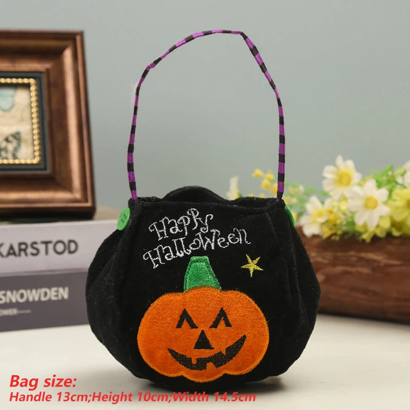Black Halloween bag with an embroidered orange pumpkin and "Happy Halloween" text. Purple striped handle. Dimensions shown: Handle 13cm, height 10cm, width 14.5cm.