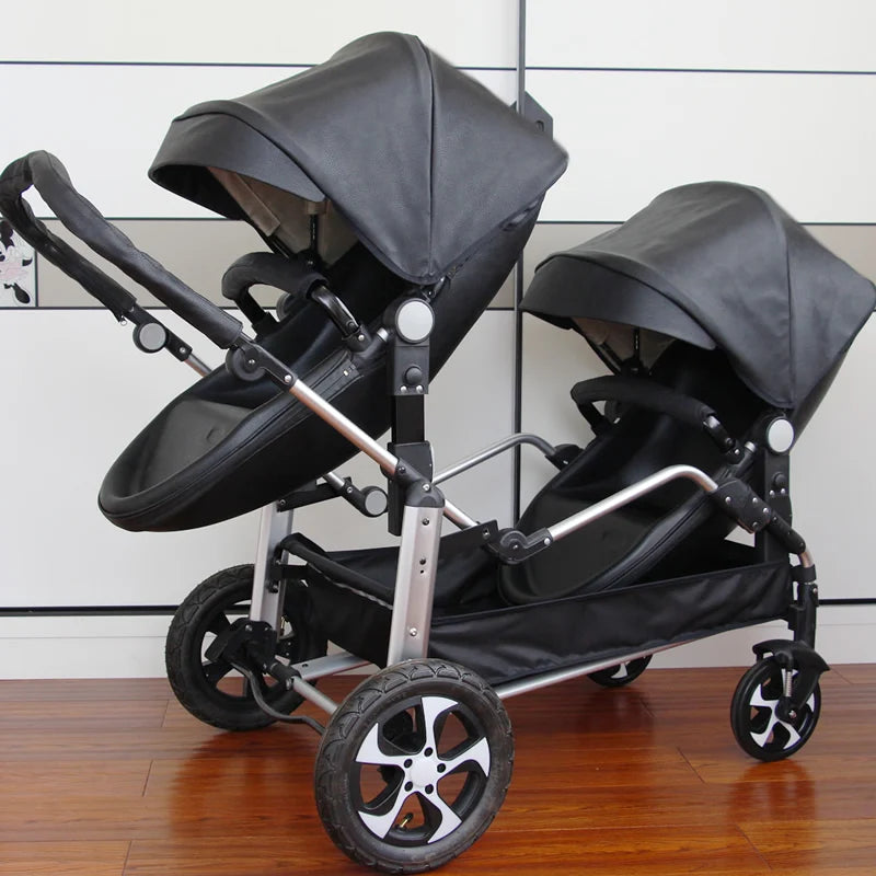 A double stroller with black seats and canopies, silver frame, and four wheels. The stroller has two seating areas, one behind the other, on a wooden floor.