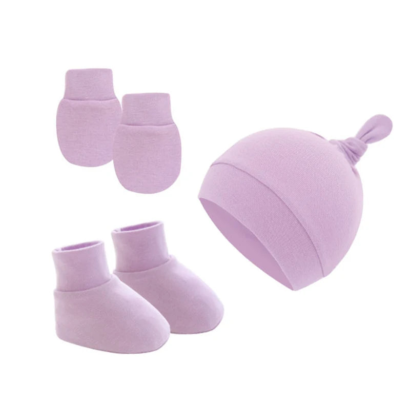 Set of pastel purple baby accessories includes a knotted hat, booties, and mittens. All items are made from soft fabric, designed for comfort and warmth.