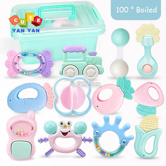 Colorful baby rattles and teethers in various shapes including a train, fish, crab, and fruit, displayed with a mint green storage box labeled "100° Boiled" and "CUTE YAN YAN".