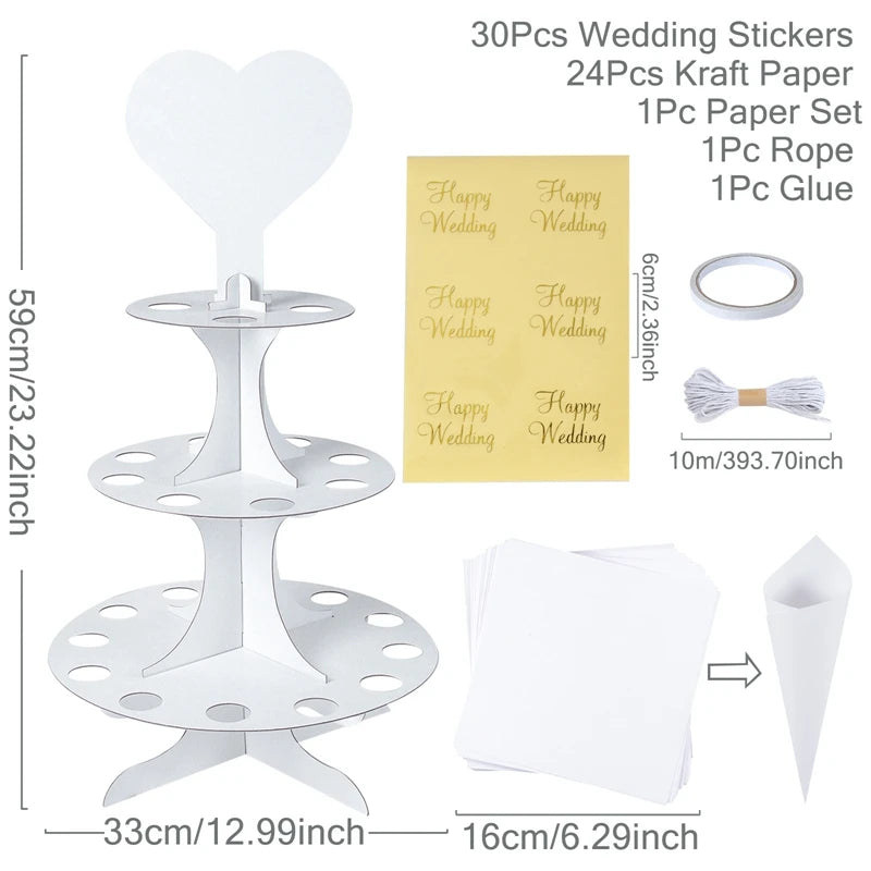 White cupcake stand with heart top, 30 wedding stickers, 24 kraft sheets, paper cone, 10m rope, and glue. Dimensions: 59cm tall, 33cm base, 16cm paper stack.