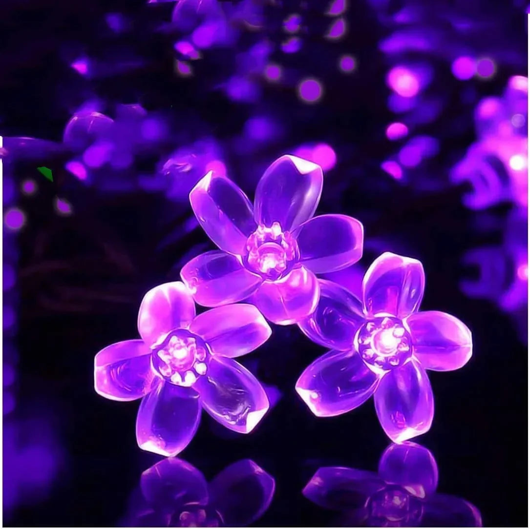 Three glowing LED flowers with translucent petals emit vibrant purple light against a dark background, creating a luminous and enchanting effect.