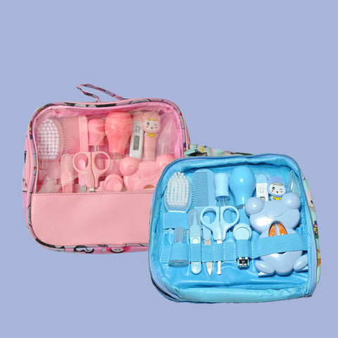 Two baby grooming kits in pink and blue cases, each containing brushes, combs, scissors, and other essential tools, displayed against a light blue background.