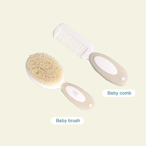 Baby grooming set with a cream-colored brush and comb. The brush has soft bristles, and both have oval grips. Labeled text identifies the items as "Baby brush" and "Baby comb."