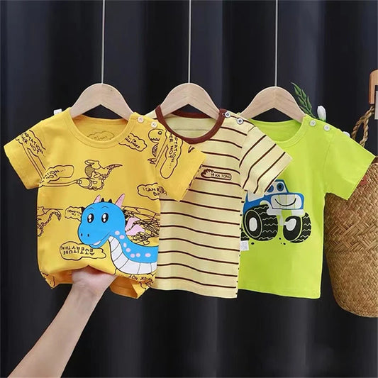 Three toddler t-shirts on hangers: yellow with a blue dinosaur print, striped yellow with a brown neckline, and bright green featuring a cartoon truck design.